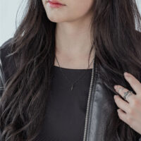 Person trägt schwarze Little Snake Kette aus Chirurgenstahl auf schwarzem Oberteil