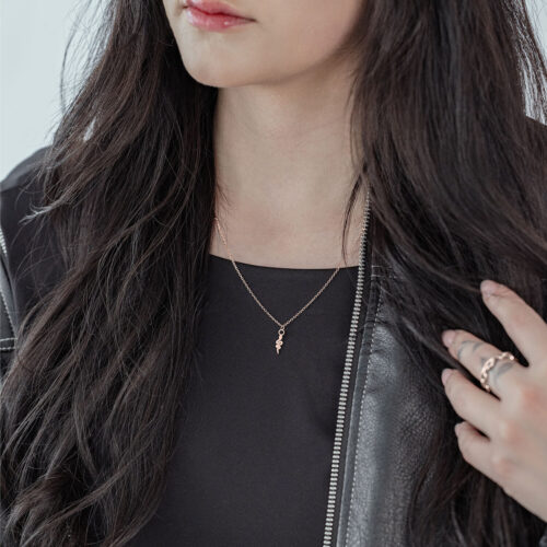 Frau mit roségoldener Little Snake Kette aus Chirurgenstahl, schwarzes Outfit