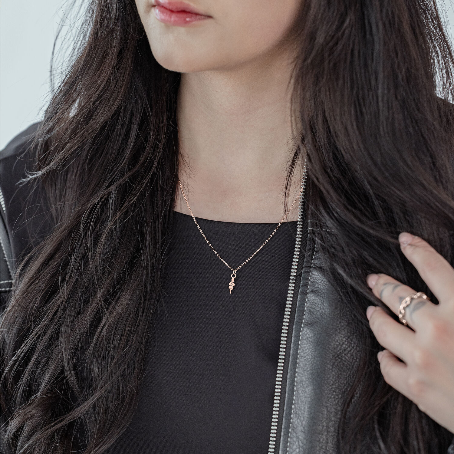 Frau mit roségoldener Little Snake Kette aus Chirurgenstahl, schwarzes Outfit
