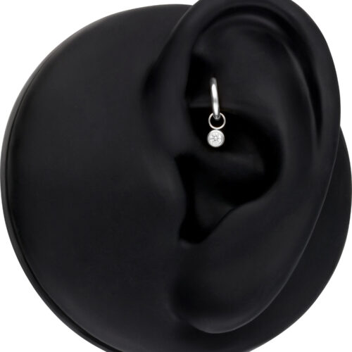 Silberner runder Kristall-Anhänger in einem schwarzen Modell-Ohr